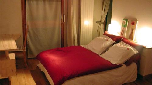 a red bed in a room with a window at Gîte Baugnac N°2 in Lavalette