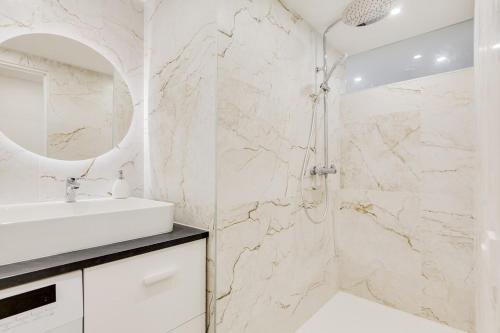 une salle de bain blanche avec un lavabo et une douche dans l'établissement Charmant Duplex Central, à Marseille