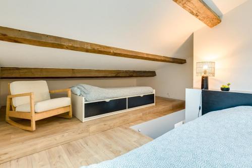 une chambre avec un lit et une chaise dans l'établissement Charmant Duplex Central, à Marseille