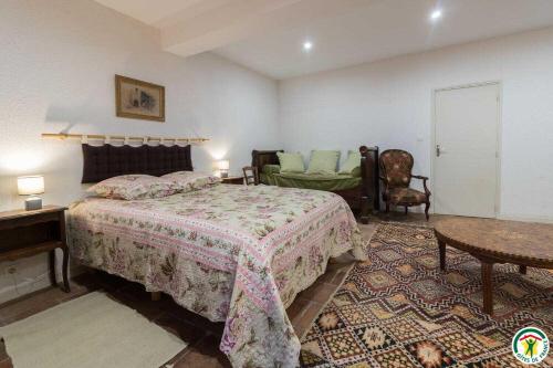 a bedroom with a bed and a table and a chair at Le parc des moutous in Aurin