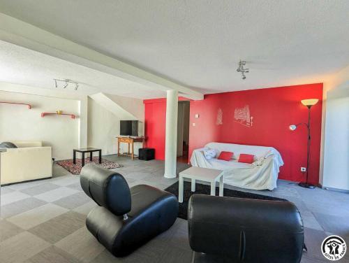 a room with a bed and a red wall at Le cagire in Labarthe-Rivière