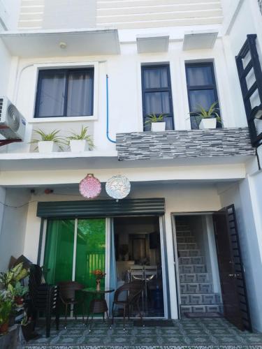 a white house with a patio with chairs and a table at Derichness in Tagbilaran City