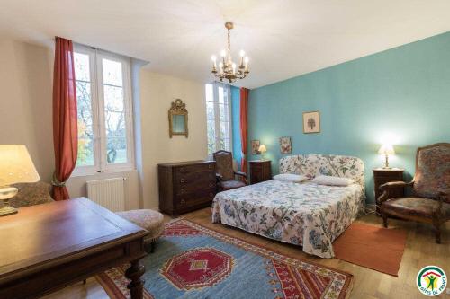 a bedroom with a bed and a table and chairs at Les pyrénées in Aurin
