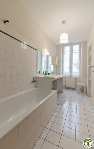 a large white bathroom with a tub and a sink at Les pyrénées in Aurin