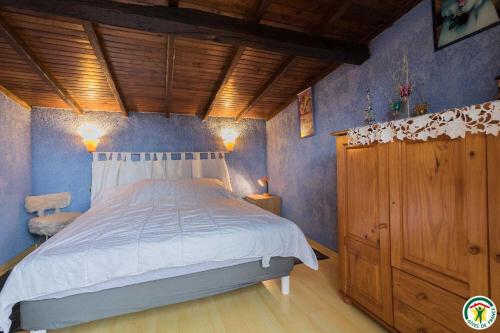 a bedroom with a large bed with blue walls at Au village in Roques Sur Garonne