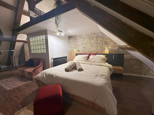 une chambre avec un grand lit et un mur de briques dans l'établissement Caen duplex T2 confort 18ème cœur de ville avec Vayny, à Caen