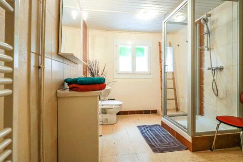 a bathroom with a toilet and a glass shower at Les platanes in Aignes