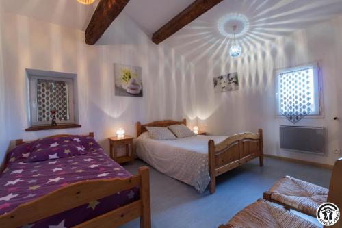 een slaapkamer met 2 bedden en een tv. bij Saint martin 2 in Beaumont-sur-Lèze