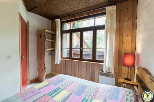 a bedroom with a bed and a large window at Le gîte de la coume in Garin
