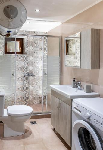a bathroom with a toilet and a washing machine at Vista Mare 2 in Afissos