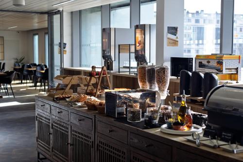 un bancone con cibo sopra in una stanza con finestre di Hôtel Lodge In Paris 13 a Parigi
