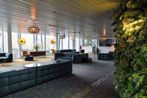 a large lobby with couches and tables and windows at Hôtel Lodge In Paris 13 in Paris