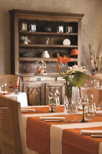 a dining room table with a vase of flowers on it at Parc Hôtel in Wangenbourg