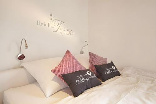 a white bed with three pillows on it at Charmingsuite in Bad Teinach-Zavelstein