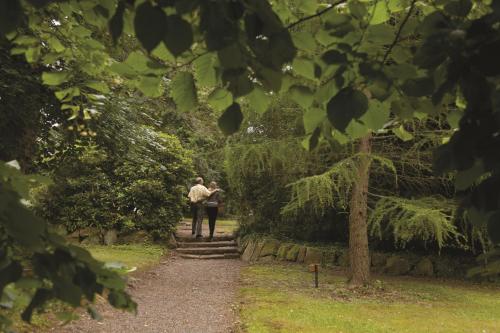 a man and a woman walking down a path at Parc Hôtel in Wangenbourg