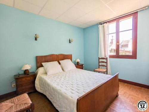 a bedroom with a large bed with blue walls at Le pequerin in Oô
