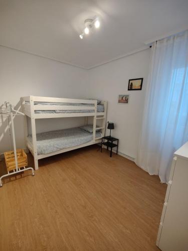 a room with two bunk beds and a wooden floor at Apartamento La Ballena 2 - Las Huertas in Santoña