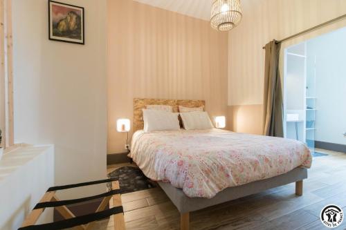 a bedroom with a bed and a large window at La grange des rampeaux in Saint-Lys