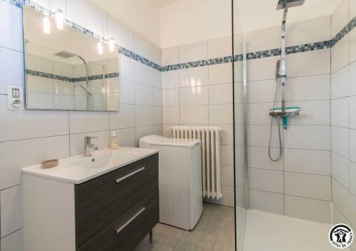 a bathroom with a toilet and a sink and a shower at Les hortensias in Aussonne