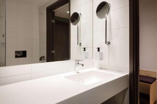 a bathroom with a white sink and a mirror at Scandic Voss in Vossevangen