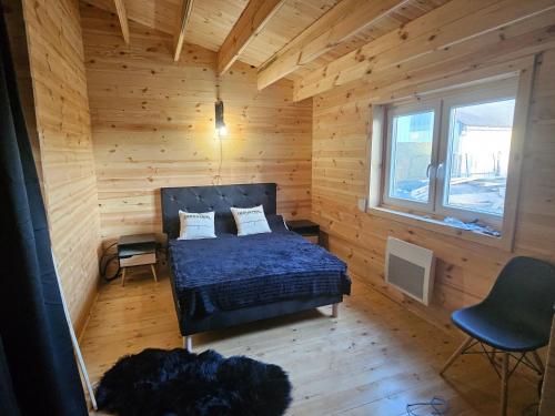 une chambre avec un lit dans une cabane en bois dans l'établissement Chalet, à Ally