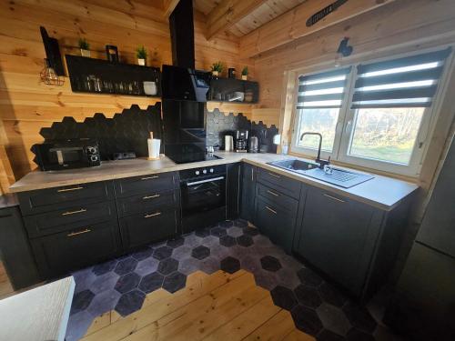 - une cuisine avec une cuisinière et un évier dans une cabine dans l'établissement Chalet, à Ally