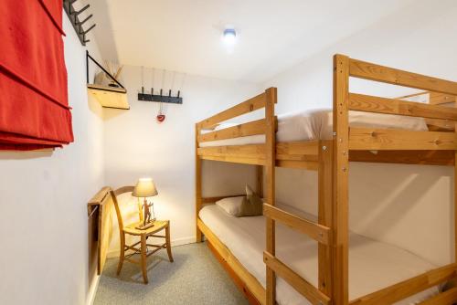 - une chambre avec 2 lits superposés et une chaise dans l'établissement Le chalet de Lili 2 pièces duplex, skis aux pieds, balcon, à Tignes