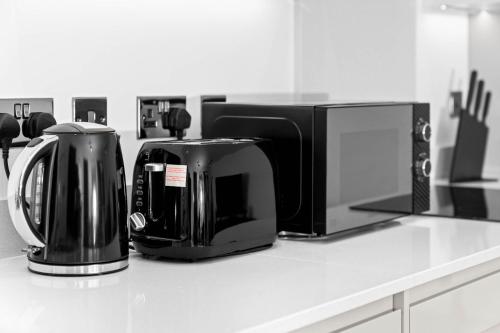 a kitchen counter with a coffee maker and a microwave at Stylish New 2-Bed Apartment in JQ in Birmingham