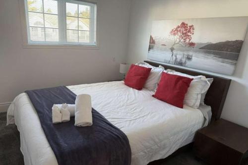 a bedroom with a large white bed with red pillows at Chalet Saint-Sauveur with heated pool during Summer and Ski in Ski out! in Saint-Sauveur-des-Monts