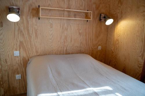 a bedroom with a bed with two lights on the wall at Domaine de Peyreguilhot in Laparade