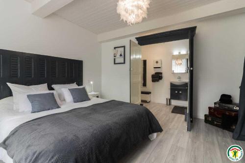 a bedroom with a large bed and a bathroom at Gîte de pene blanque in Arbas