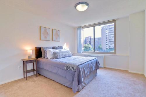 a bedroom with a bed and a large window at Prime Location! Spacious & Comfy in Arlington