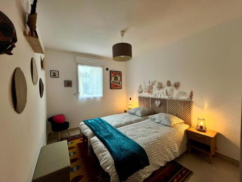 - une chambre avec un lit doté d'une couverture bleue dans l'établissement Azur Plage, à Fréjus