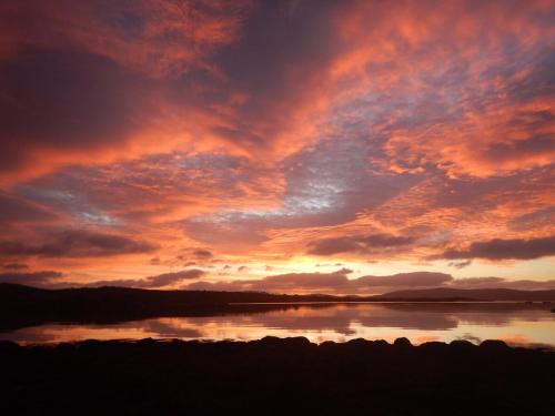 a sunset over a large body of water at Adrigole Bay Studio Apartment in Adrigole