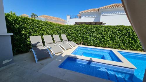 a group of chairs sitting next to a swimming pool at Villa with private pool and jacuzzi - EN10LT in Torre-Pacheco