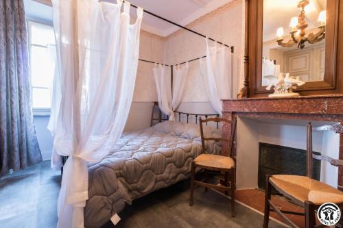 a bedroom with a bed with a fireplace and a mirror at Gîte les ecureuils in Montclar-de-Comminges
