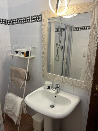 a bathroom with a sink and a shower and a mirror at Appartamento Margarita Maris - 20mt dalla Spiaggia in Follonica