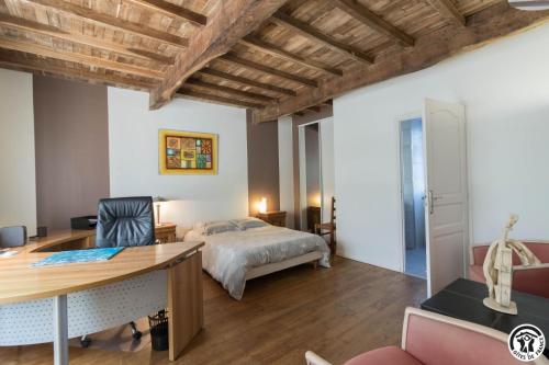 a bedroom with a bed and a desk in a room at La grande ferme in Ponlat-Taillebourg