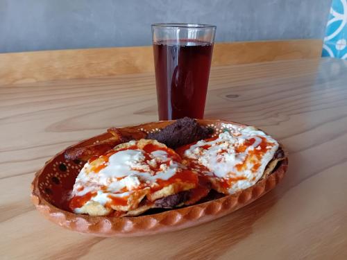 a plate of food and a glass of soda at Hotel Momotus Tuxtla - Desayuno opcional in Tuxtla Gutiérrez