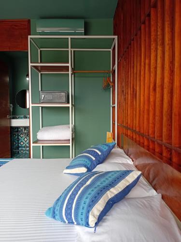 a bed with blue and white pillows in a room at Hotel Momotus Tuxtla - Desayuno opcional in Tuxtla Gutiérrez