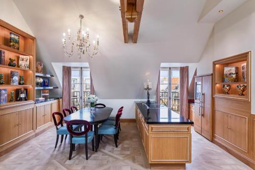 a dining room with a table and chairs and a chandelier at Maison Barrière Vendôme in Paris