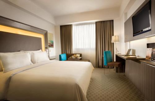 A bed or beds in a room at Novotel Bangka Hotel & Convention Center