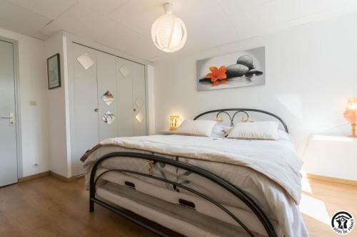 a bedroom with a large bed with white walls at Vacances garonne toulouse in Saubens