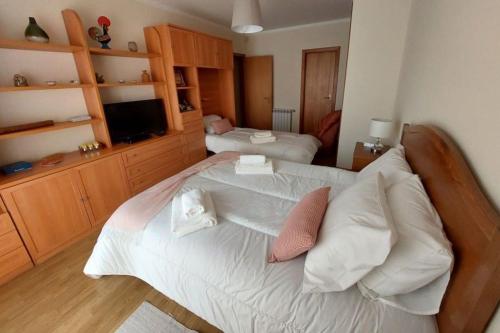 a bedroom with a large bed with white sheets and pillows at Silver Waves in Vila Nova de Gaia