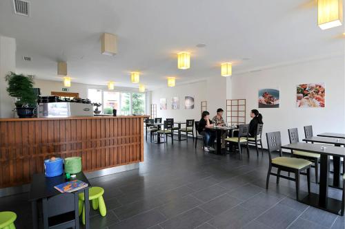 a restaurant with people sitting at tables in a room at Miyabi 1 in Maribor