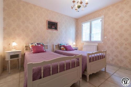 a bedroom with two beds and a window at Le clos bleu in Gauré