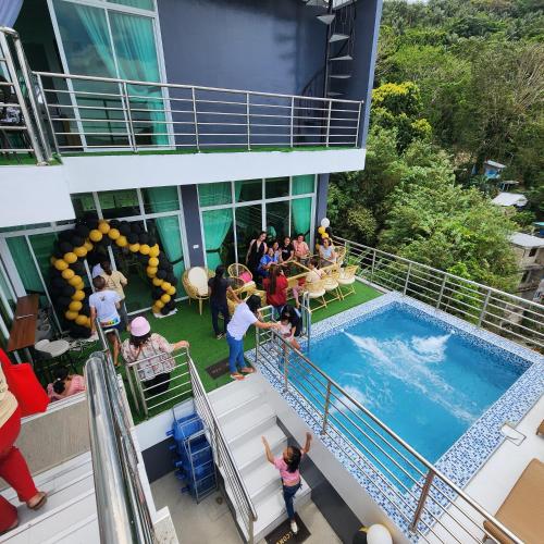 a group of people standing around a swimming pool on a building at Yurich Hotel in Romblon