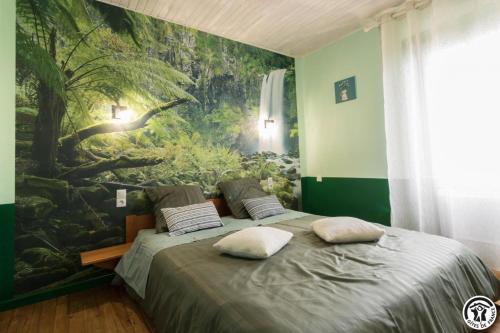 a bedroom with a bed with a painting on the wall at Comà a l'ostal in Montégut-Lauragais