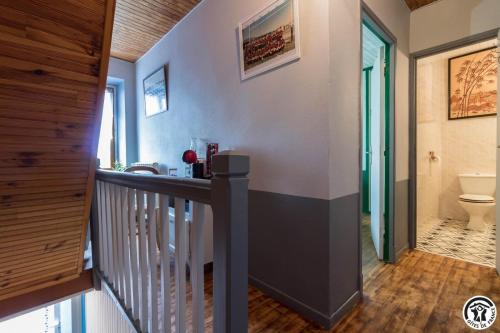 a hallway with a bathroom with a toilet and a staircase at Comà a l'ostal in Montégut-Lauragais