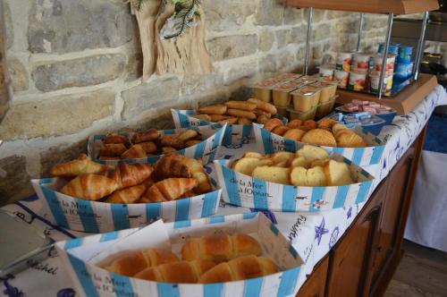 a table with several baskets of bread and pastries at Hotel La Chaudrée in La Brée-les-Bains